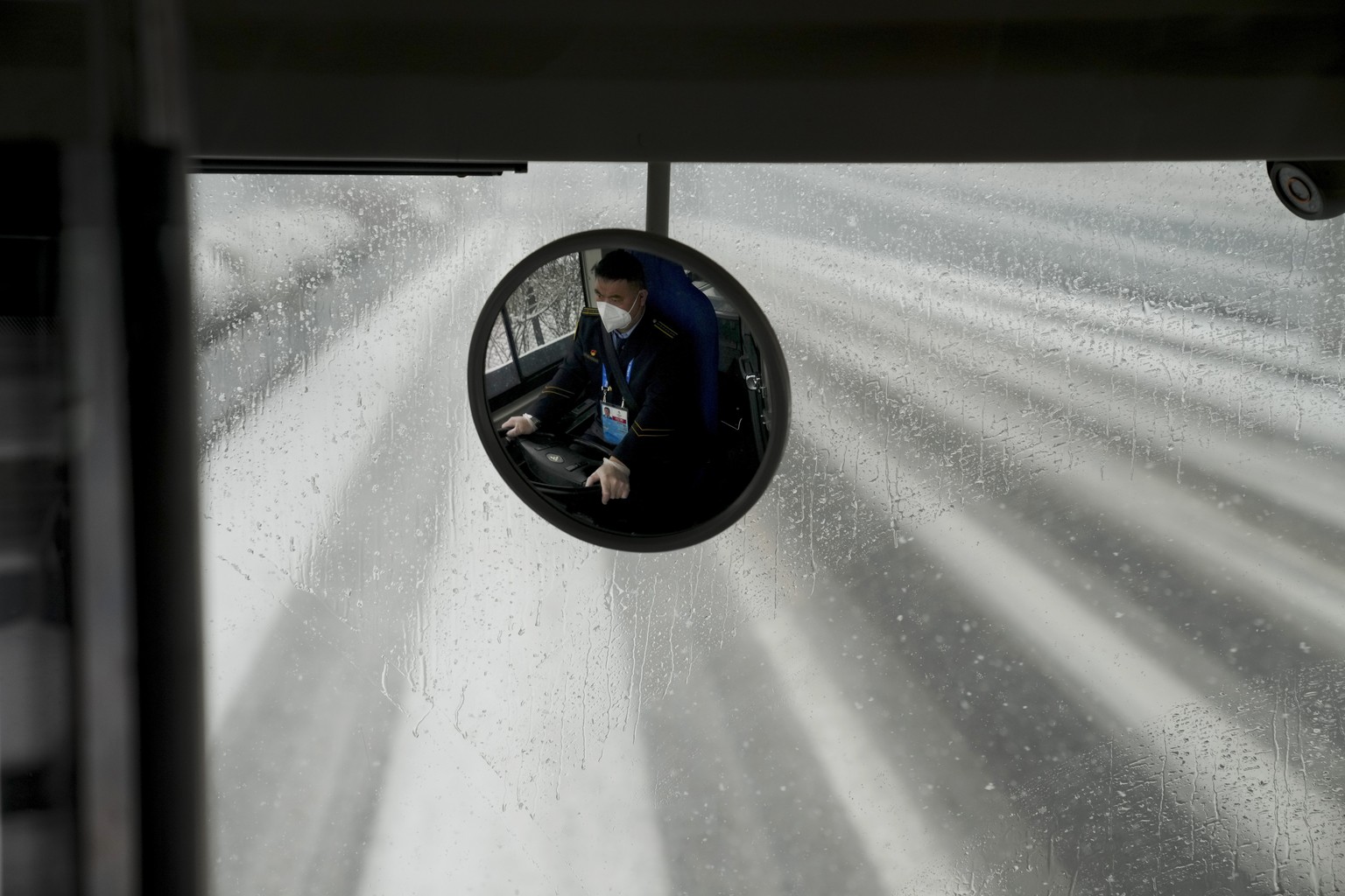 A man drives a bus at the 2022 Winter Olympics, Sunday, Feb. 13, 2022, in Beijing. (AP Photo/Natacha Pisarenko)