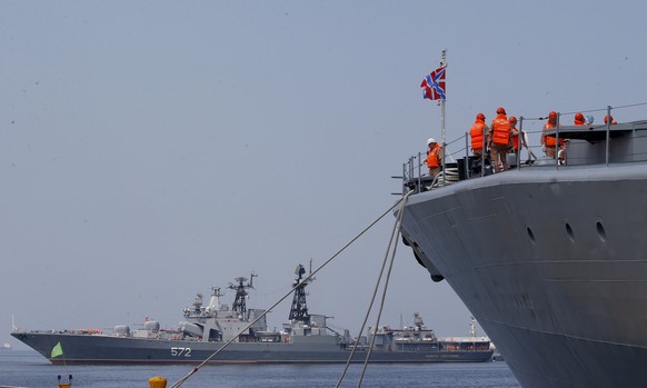 The crew of the Russian Navy destroyer Admiral Tributs secure their ship as the Russian destroyer Vinogradov, rear, prepares to dock at Manila&#039;s South Harbor Monday, April 8, 2019, in Manila, Phi ...