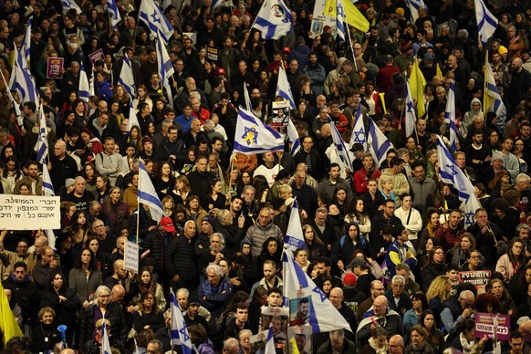 epa11981909 Israeli hostage family members, supporters and anti-government activists protesting outside the Kirza Defence Ministry headquarters in Tel Aviv, Israel, 22 March 2025, against the resumpti ...