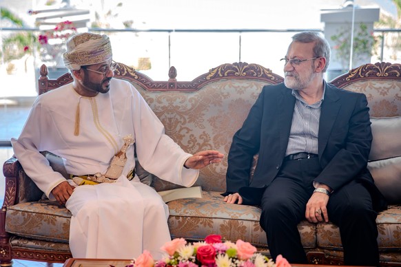 In this photo released by Iran's Supreme National Security Council office, Secretary of the Supreme National Security Council Ali Larijani, right, listens to Omani Foreign Minister Badr al-Busaid ...