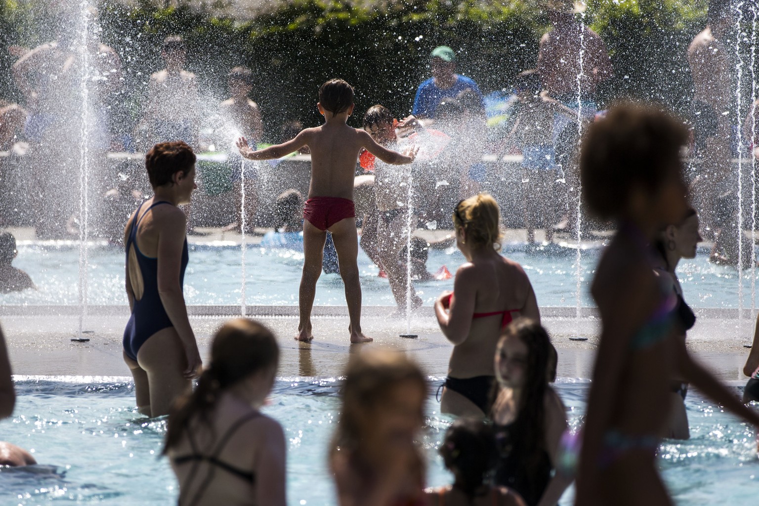 Badegäste geniessen das kühle Wasser im Freibad in Winterthur.