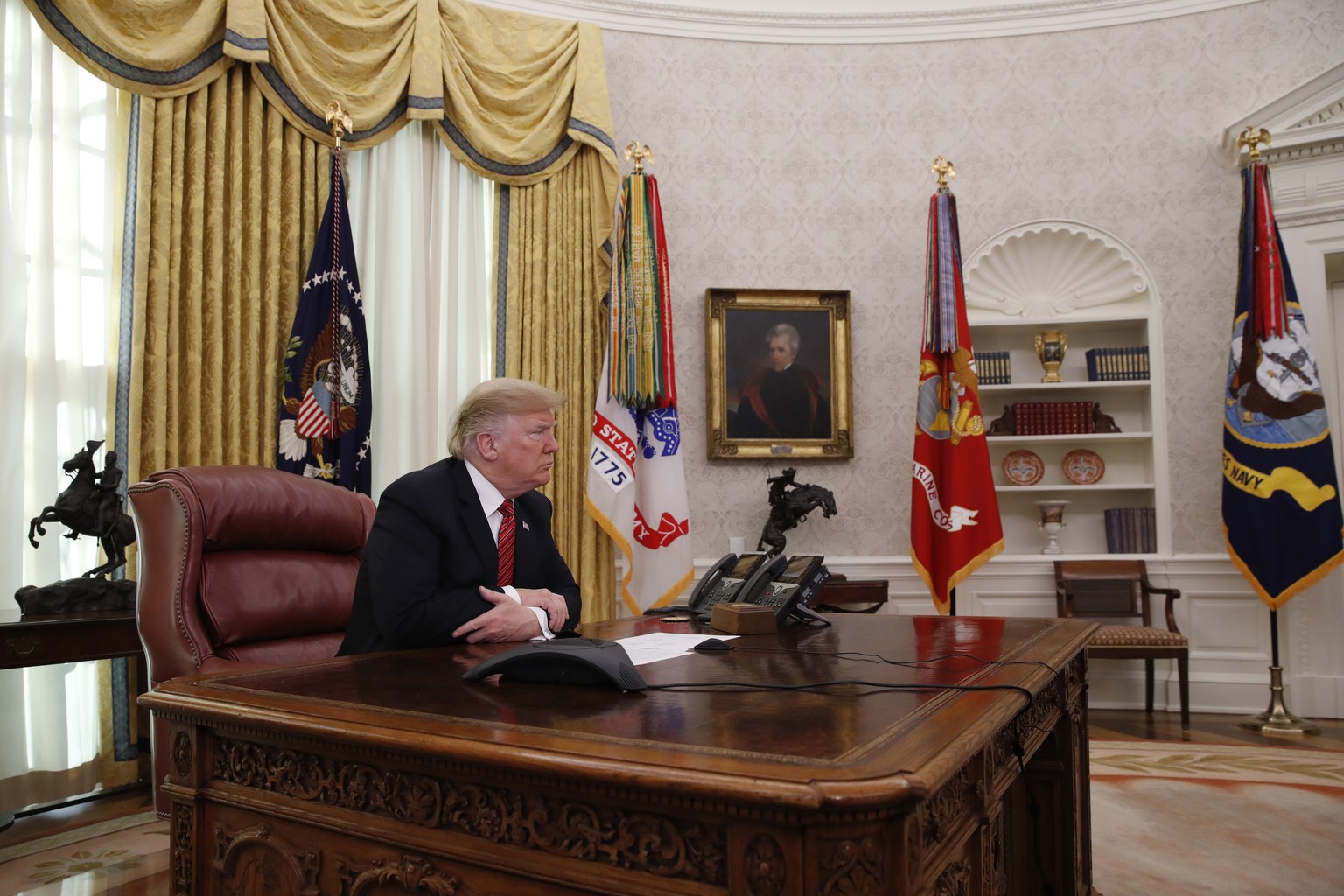 President Donald Trump pauses while speaking to members of the five branches of the military by video conference on Christmas Day, Tuesday, Dec. 25, 2018, in the Oval Office of the White House. The mi ...