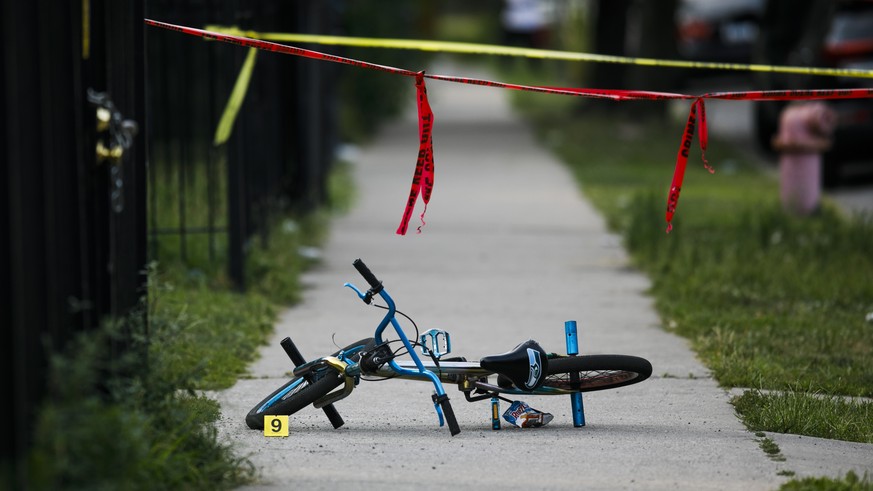 In this Sunday, Aug. 5, 2018 photo, evidence markers sit on the ground at the scene where a boy was killed after being shot in the abdomen while riding his bike in Chicago. Police Superintendent Eddie ...