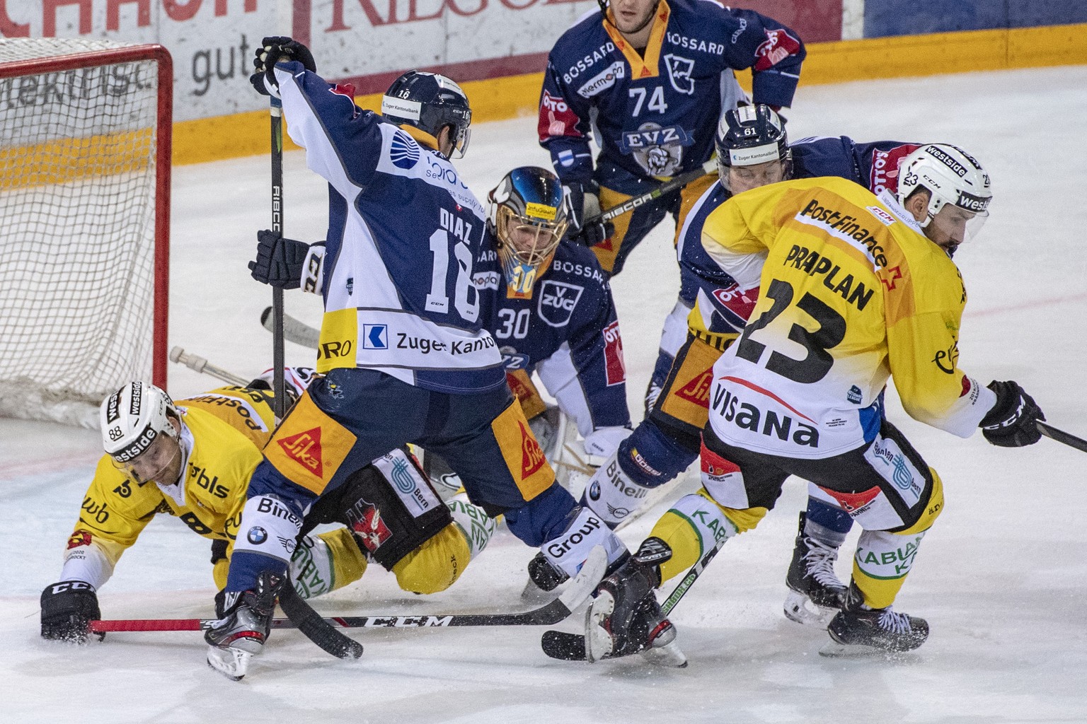 Torhueter Leonardo Genoni, mitte, im Spiel gegen Vincent Praplan, rechts, von Bern Eishockey Meisterschaftsspiel in der Qualifikation der National League zwischen dem EV Zug und dem SC Bern vom Montag ...