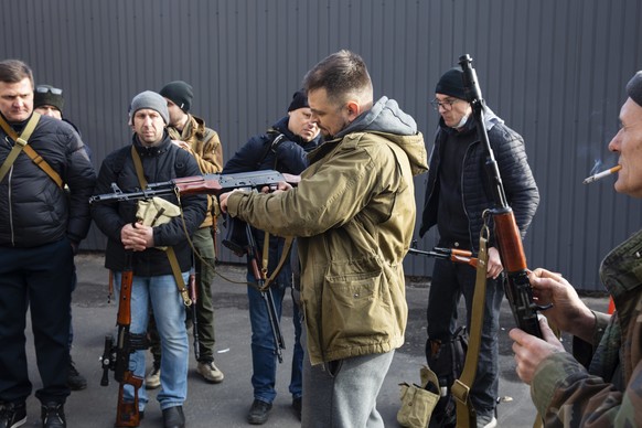 Civilian Members of a territorial defence unit fit their weapons to repel the Russian attacking forces in Kyiv, Ukraine, Saturday, Feb. 26, 2022. Russian troops stormed toward Ukraine&#039;s capital S ...