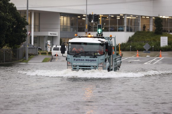 Men drive a truck through flood water in Auckland, New Zealand, Wednesday, Feb. 1, 2023. A heavy rain warning for Auckland was lifted, although a state of emergency remained in place for the nation&#0 ...