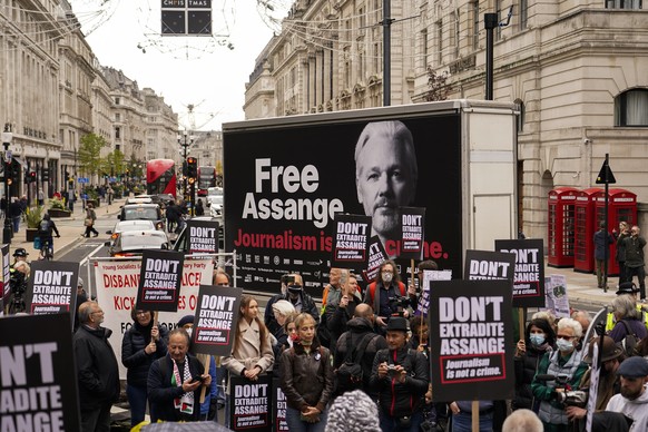 Supporters of WikiLeaks founder Julian Assange hold placards and take part in a march in London, Saturday, Oct. 23, 2021, ahead of next week&#039;s extradition case appeal. (AP Photo/Alberto Pezzali)