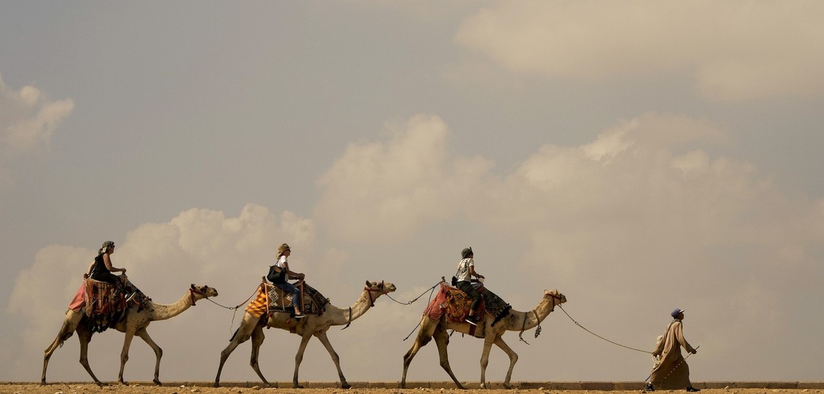 Tourists take a camel ride at the site of Giza Pyramids in Giza, near Cairo, Egypt, Wednesday, Nov. 2, 2022. (AP Photo/Amr Nabil)