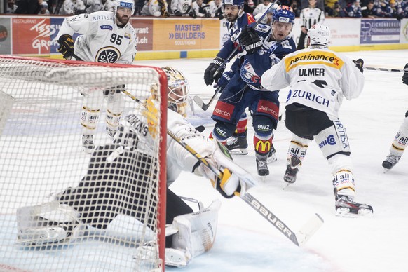 Zuercher Ronalds Kenins, rechts, kaempft um den Puck gegen Luganos Goalie Elvis Merzlikins im zweiten Eishockey Playoff-Finalspiel der National League zwischen den ZSC Lions und dem HC Lugano am Samst ...