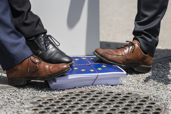 KEYPIX - SVP Nationalrat Marcel Dettling, SZ, SVP Praesident, und zwei weitere SVP Nationalraete stehen in einer Inszenierung auf einen geschnuerten Stapel Papier, welcher die Vertraege mit der EU rep ...