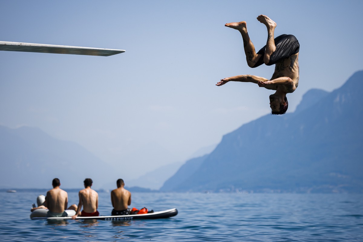 A man jumps into Lake Geneva in Saint-Saphorin, Switzerland, Saturday, June 18, 2022. People flocked to parks and pools across Western Europe on Saturday for a bit of respite from an early heat wave t ...