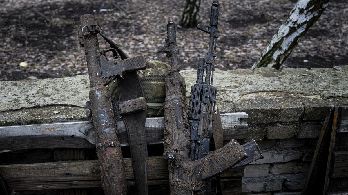 Mud-stained guns of Ukrainian soldiers are seen on the street of Chasiv Yar, Ukraine, Wednesday, March 8, 2023. (AP Photo/Evgeniy Maloletka)