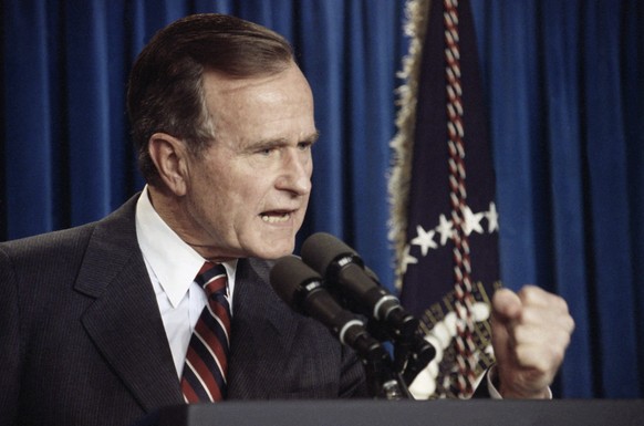 U.S. President George H. Bush makes a fist as he answers questions from reporters during a news conference at the White House in Washington, Wednesday, Jan. 9, 1991. The president called the press con ...