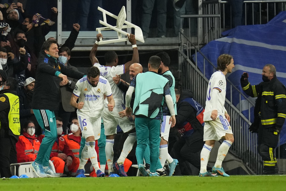Real Madrid players celebrate with a chair after scoring their side's third goal during the Champions League, round of 16, second leg soccer match between Real Madrid and Paris Saint-Germain at t ...