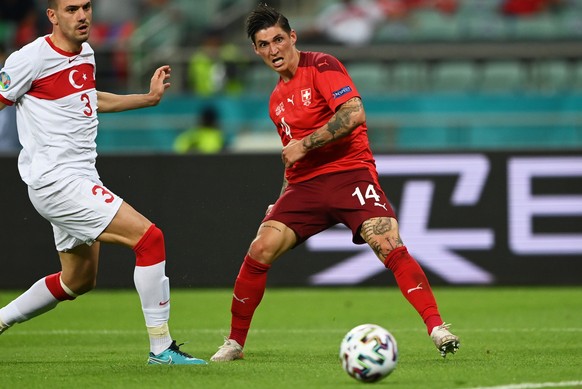 epa09288962 Steven Zuber (R) of Switzerland takes a shot at goal under pressure from Merih Demiral of Turkey during the UEFA EURO 2020 group A preliminary round soccer match between Switzerland and Tu ...