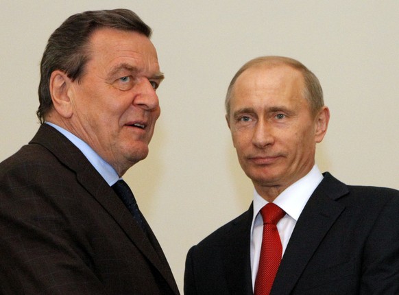 FILE-In this April 14, 2009 file photo then Russian Prime Minister Vladimir Putin, right, and former German chancellor Gerhard Schroeder seen during their meeting in St. Petersburg, Russia. Schroeder  ...