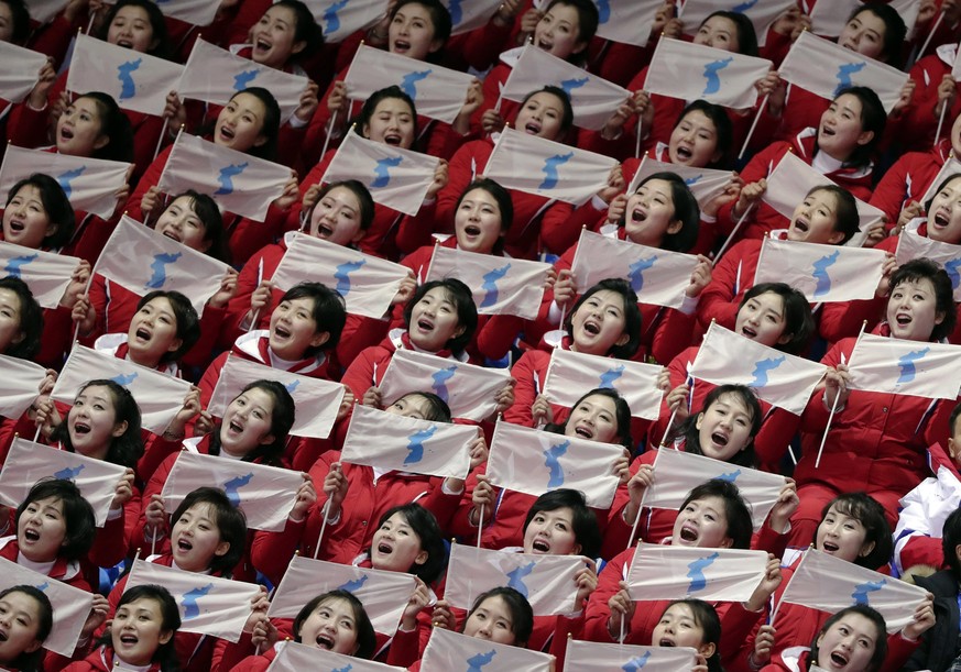 North Korean supporters hold up the Korean unification flags during the ladies&#039; 500 meters short-track speedskating in the Gangneung Ice Arena at the 2018 Winter Olympics in Gangneung, South Kore ...