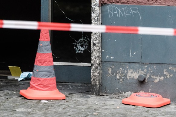 epa08904703 A bullet hole can be seen in the glass of an entrance door of a residential building during investigations at the crime scene in Berlin, Germany, 26 December 2020. Media reports state, tha ...