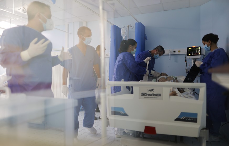 epa09440317 Doctor Nderim Hasani (3-R) joined by nurses inside the intensive care unit (ICU) tends to a patient with COVID-19 in the Clinic for Infectious Diseases, in Pristina, Kosovo, 01 September 2 ...