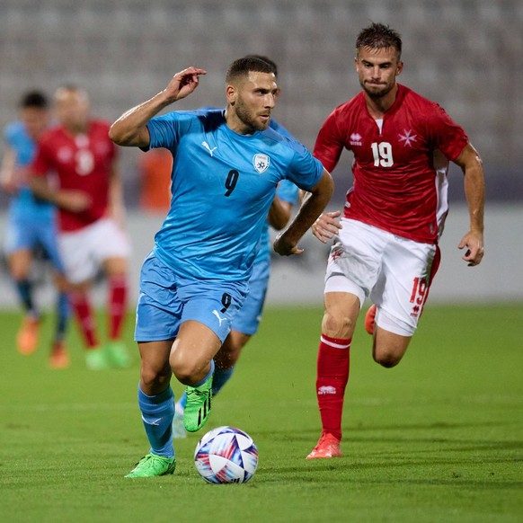 Israel national soccer team player Shon Weissman L moves with the ball ahead of Bjorn Kristensen R of Malta during the friendly international soccer match between Malta and Israel at the National Stad ...