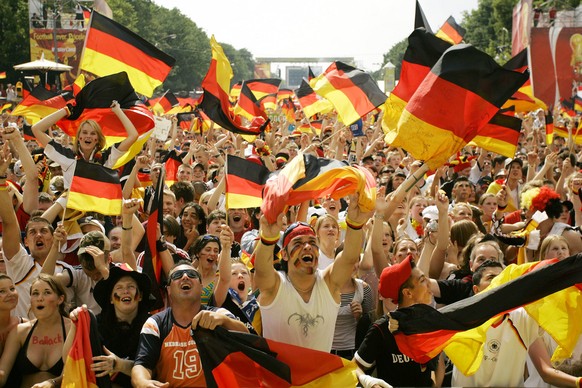 German soccer fans cheer as Germany scores the first goal during the World Cup soccer match Germany against Ecuador as they watch the game on a giant TV screen at the public viewing area in Berlin, Tu ...