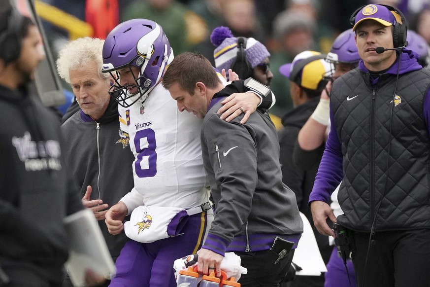Minnesota Vikings quarterback Kirk Cousins (8) is helped off the field after going down with an injury in the fourth quarter of an NFL game against the Green Bay Packers, Sunday, Oct. 29, 2023, in Gre ...