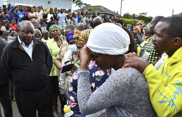 In this photo provided by the South African Government Communications and Information Services (GCIS), South Africa&#039;s President Cyril Ramaphosa, left, speaks to various grieving family members, a ...