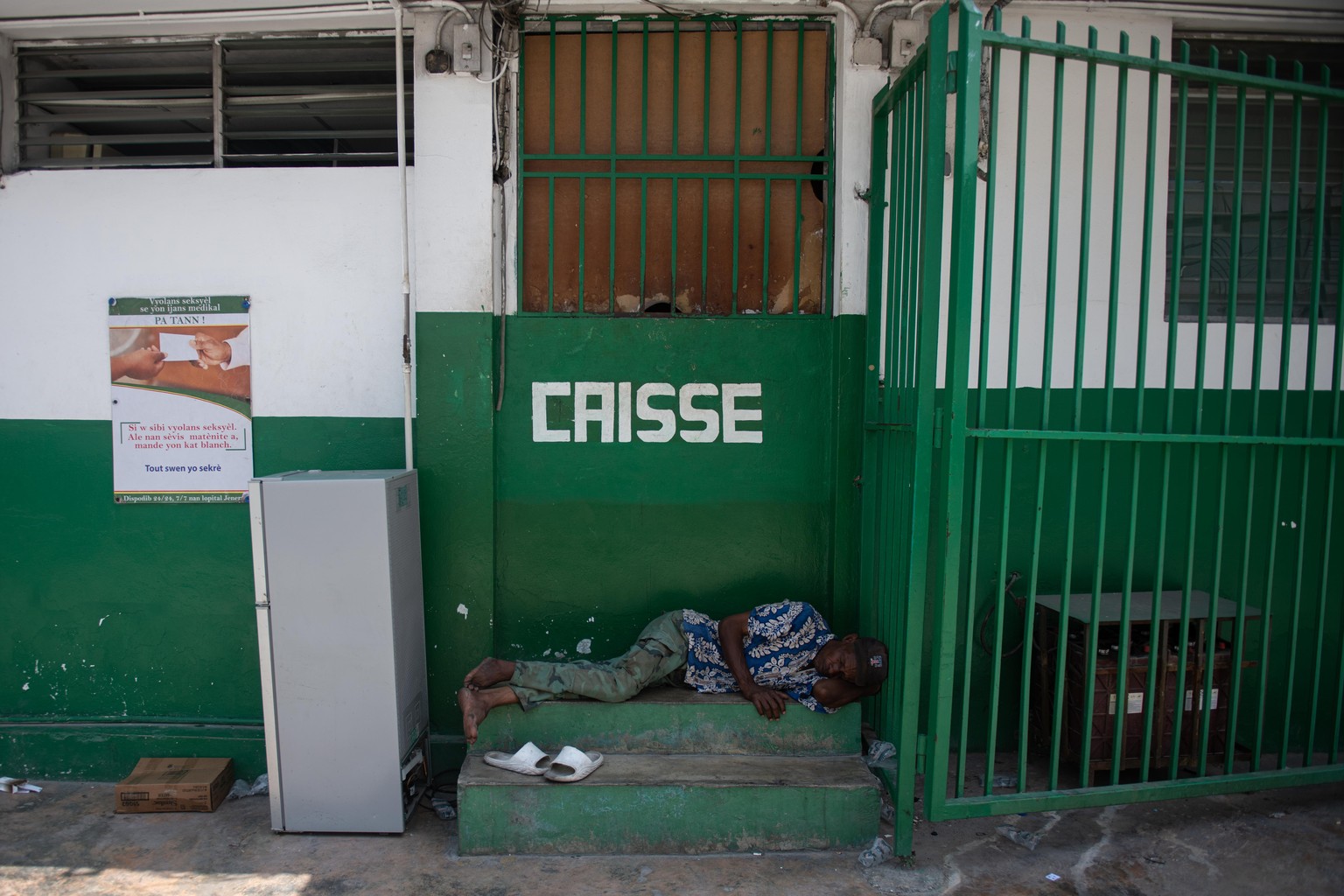 epa11246034 A man sleeps next to Haiti State University Hospital, a facility that has been abandoned for about a month in Port-au-Prince, Haiti, March 26, 2024. Downtown Port-au-Prince is...