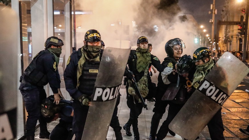 epa10367946 Police officers confront protesters outside the Palace of Justice in Lima, Peru, 15 December 2022. At least six protesters have died in the first 20 hours after the state of emergency was  ...