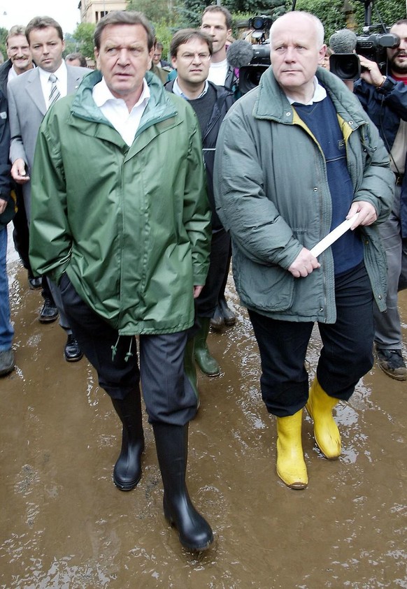 German Chancellor Gerhard Schroeder, left, and Saxony Governor Georg Milbradt, right, walk in the town center of Grimma, eastern Germany, Wednesday, August 14, 2002. Booth politician visited the Saxon ...