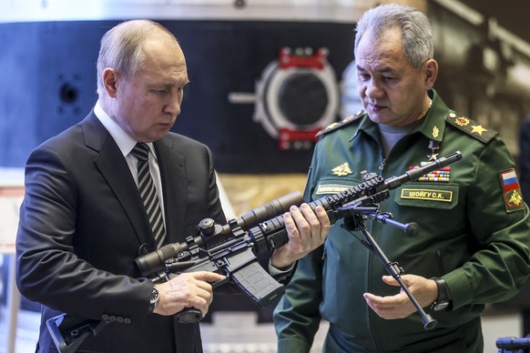 Russian President Vladimir Putin, left, and Russian Defense Minister Sergei Shoigu visit an military exhibition after attending an extended meeting of the Russian Defense Ministry Board at the Nationa ...