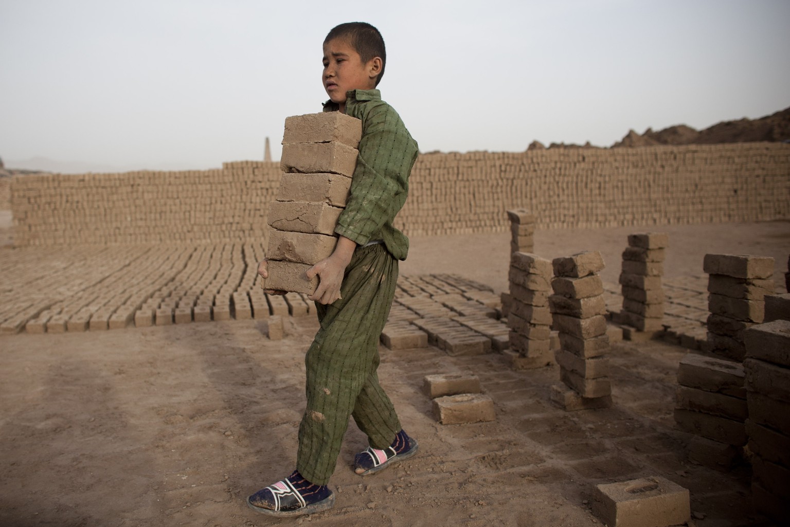 Ein Junge trägt Ziegel in einer Ziegelfabrik in Afghanistan. Rund 115 Millionen Kinder arbeiten unter «schlimmsten Bedingungen». Bedingungen, die zum Tod oder zu nachhaltigen Schäden führen können.