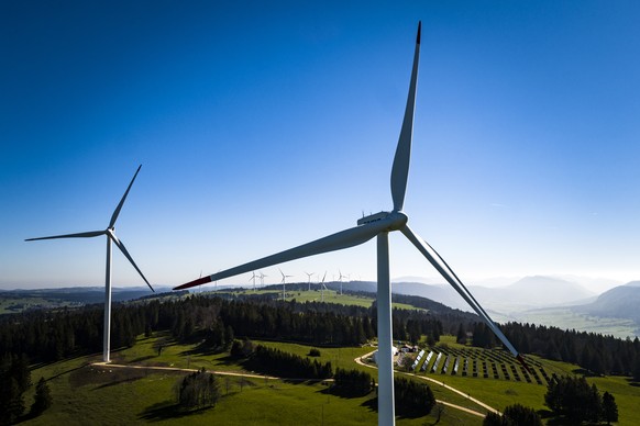 ARCHIVBILD - Nationalrat stimmt am 8. Maerz 2023 fuer Windenergieoffensive - Wind turbines from the JUVENT power plant and solar panels from the solar station of the Mont-Soleil are pictured on the Mo ...