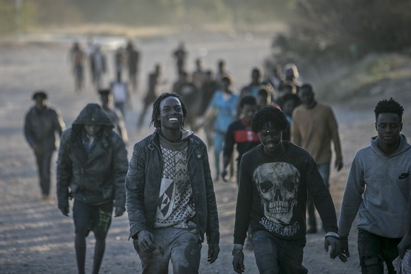 Migrants arrive on Spanish soil after crossing the fences separating the Spanish enclave of Melilla from Morocco, in Melilla, Spain, Thursday March 3, 2022. Hundreds of Africans have tried to climb ov ...