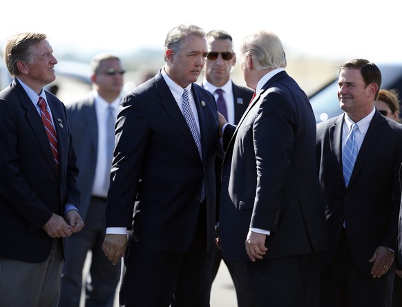 President Donald Trump speaks with Rep. Trent Franks, R-Ariz., third from left, after stepping off Air Force One as he arrives Tuesday, Aug. 22, 2017, in Phoenix. At right is Arizona Gov. Doug Ducey.  ...