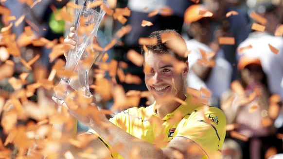 John Isner holds the trophy after defeating Alexander Zverev, of Russia, in the final at the Miami Open tennis tournament, Sunday, April 1, 2018, in Key Biscayne, Fla. Isner won, 6-7 (4), 6-4, 6-4. (A ...