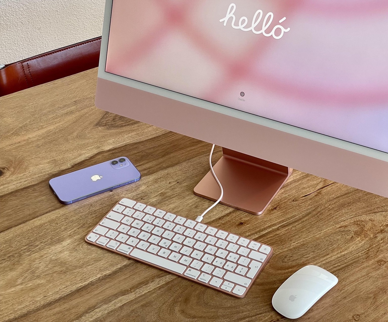 iMac 24 Zoll mit M1-Chip, 2021, dazu ein iPhone 12 (violett).