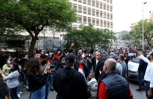 epa08805447 Anti-government protesters carry banners and shout slogans against the policy of the Central Bank during protest in front of the Central Bank of Lebanon in Beirut, Lebanon, 07 November 202 ...