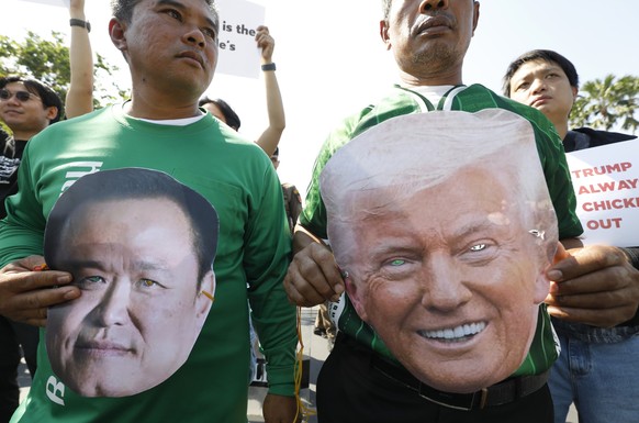 epa12563625 Thai demonstrators wearing masks of US President Donald Trump (R) and Thai Prime Minister Anutin Charnvirakul (L) attend a protest against a Thai-USA Memorandum of Understanding (MOU) on r ...