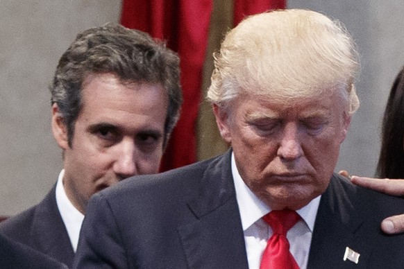 FILE - People lay hands in prayer on Republican presidential candidate Donald Trump, right, as attorney Michael Cohen looks on during a visit to the Pastors Leadership Conference at New Spirit Revival ...