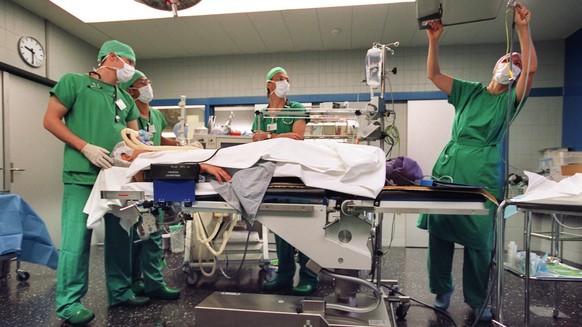 Aerzte bereiten im Operationssaal der Schaedel, Kiefer-und Gesichtschirurgie des Inselspitals Bern einen Patienten auf die Anaesthesie vor, aufgenommen am 26. Oktober 2004. (KEYSTONE/Gaetan Bally) === ...