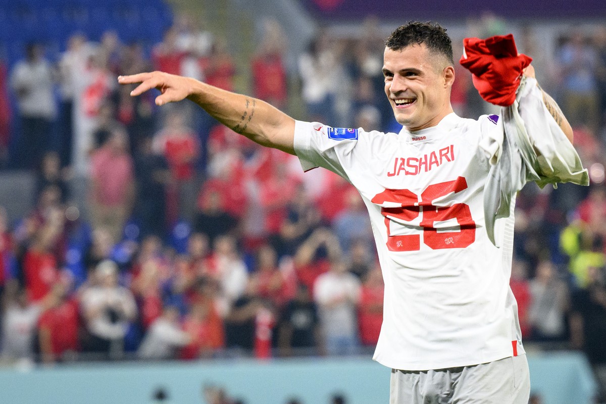 Switzerland's midfielder Granit Xhaka celebrates the victory and the qualification with the shirt of Switzerland's midfielder Ardon Jashari after the FIFA World Cup Qatar 2022 group G soccer ...