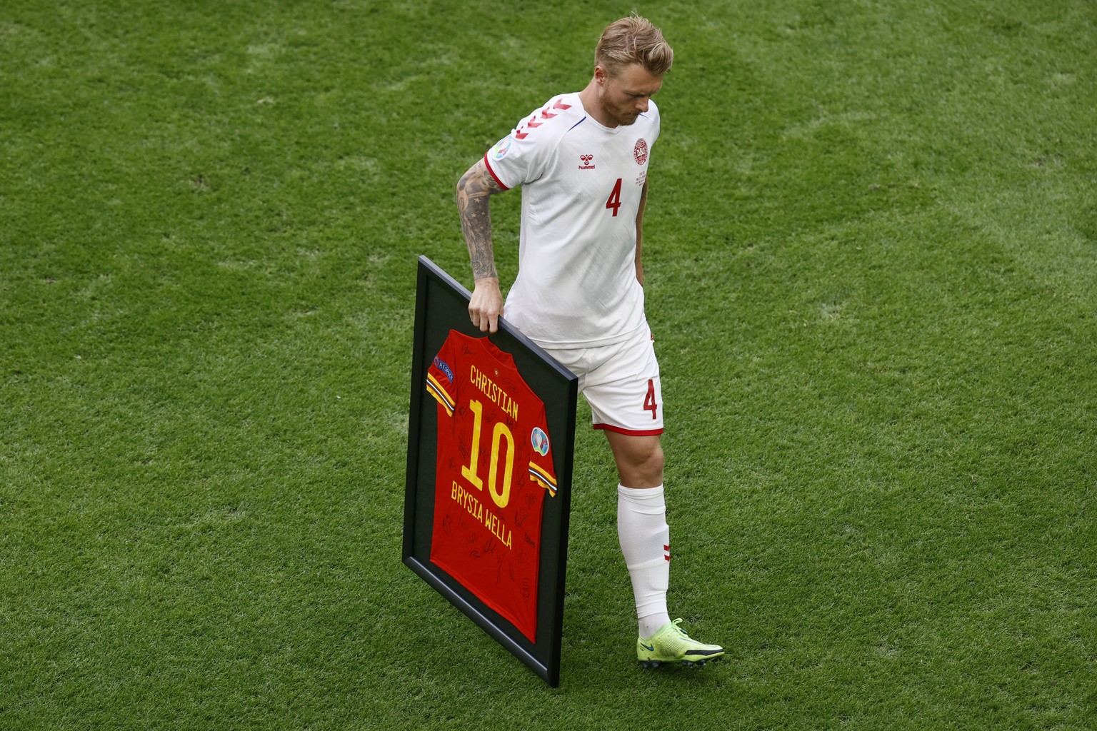 Denmark&#039;s Simon Kjaer carries a jersey dedicated to his teammate Christian Eriksen which was handed over by Gareth Bale of Wales during the Euro 2020 soccer championship round of 16 match between ...
