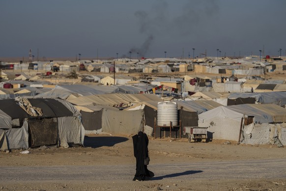 FILE - A woman walks in the al-Hol camp in northeastern Syria&#039;s Hasakeh province, where tens of thousands of mostly women and children linked to the Islamic State group have been living for years ...