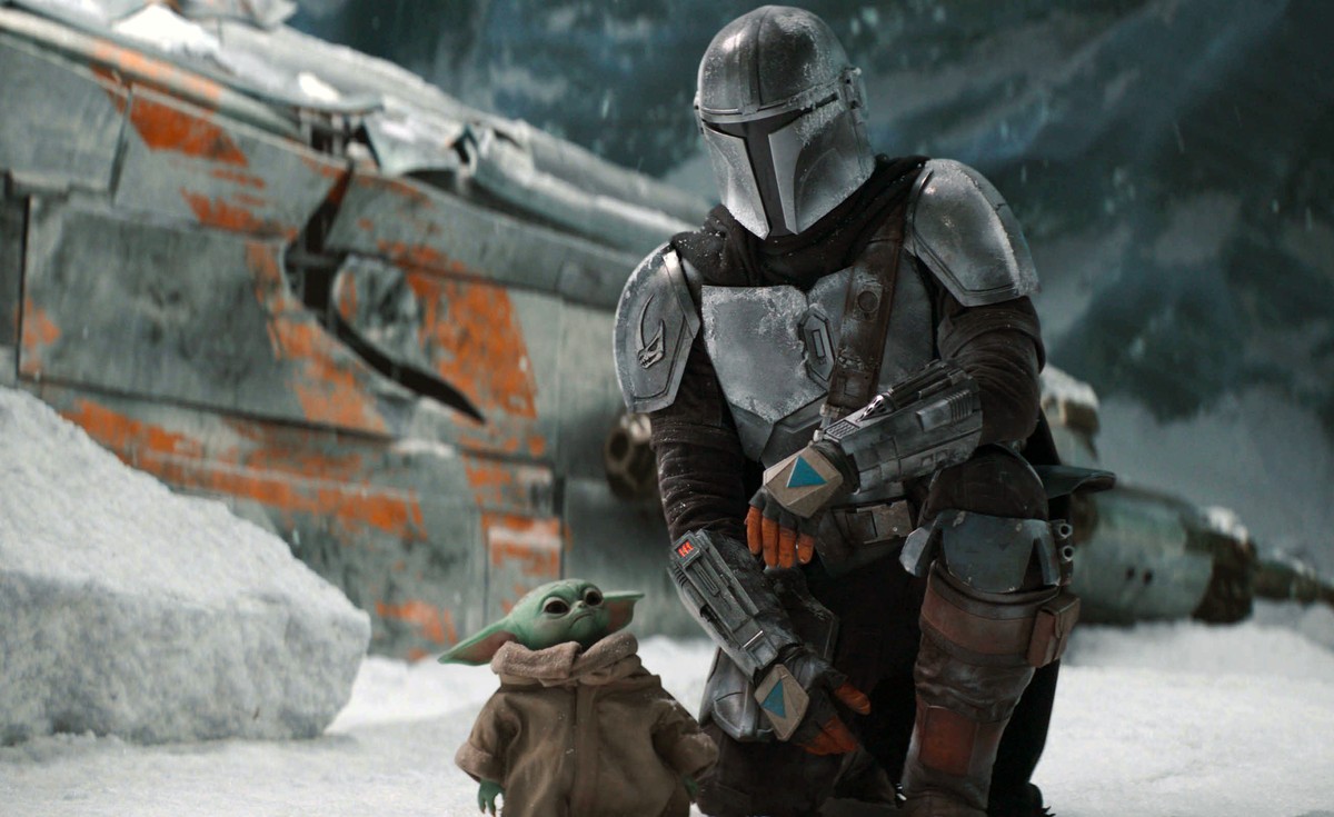 This image released by Disney Plus shows Pedro Pascal, as Din Djarin, right, with The Child, in a scene from "The Mandalorian," premiering its second season on Friday. (Disney Plus via AP)