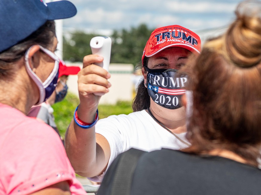October 12, 2020 - Sanford, FL, U.S: A volunteer checks temperatures before entry to the Republican presidential nominee Donald Trump rally at Orlando Sanford International Airport Million Air Hanger ...