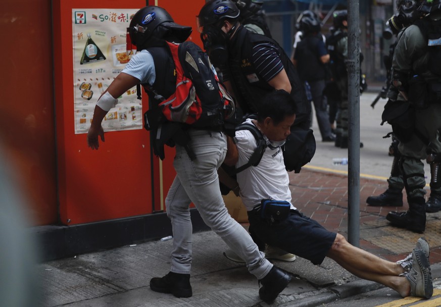 An injured anti-government protester is attended to by others during a clash with police in Hong Kong, Tuesday, Oct. 1, 2019. Thousands of black-clad protesters marched in central Hong Kong as part of ...