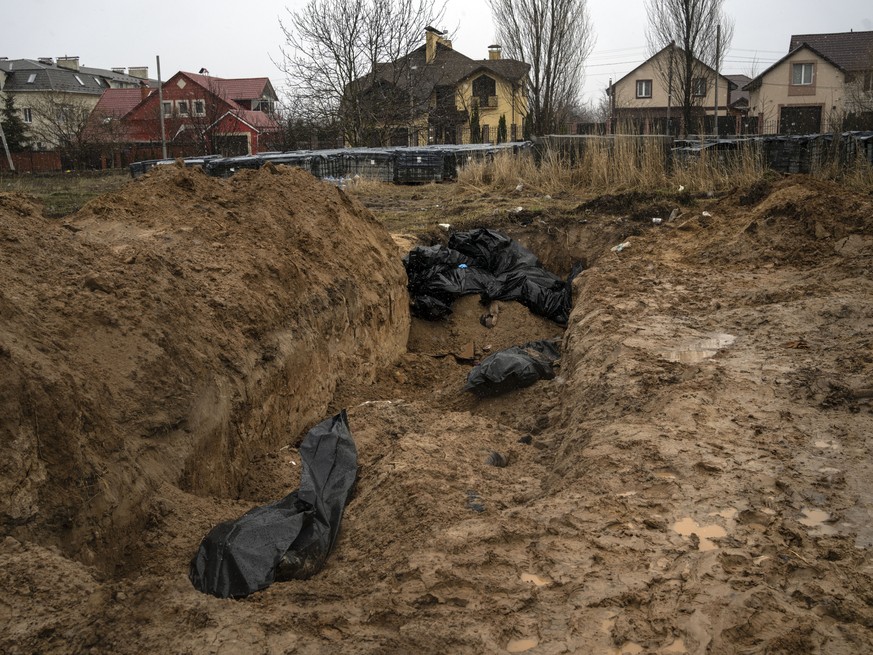 Bodies lie in a mass grave in Bucha, on the outskirts of Kyiv, Ukraine, Sunday, April 3, 2022. Ukrainian troops are finding brutalized bodies and widespread destruction in the suburbs of Kyiv, sparkin ...