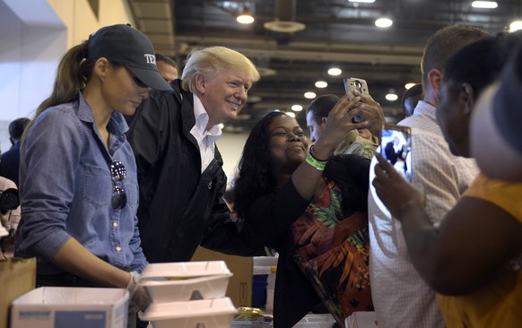 President Donald Trump and Melania Trump pass out food and meet people impacted by Hurricane Harvey during a visit to the NRG Center in Houston, Saturday, Sept. 2, 2017. TIt was his second trip to Tex ...