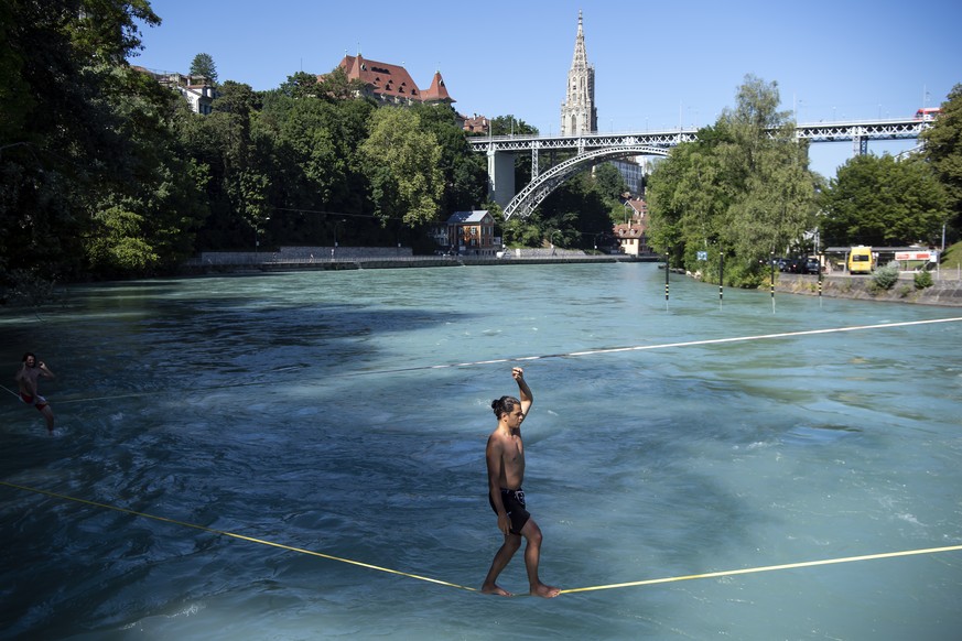 People on slacklines above the Aare river during a hot summer day, in Bern, Switzerland, Friday, June 28, 2019. The forecast predicts hot weather in Switzerland with maximum temperature at 38 degrees  ...
